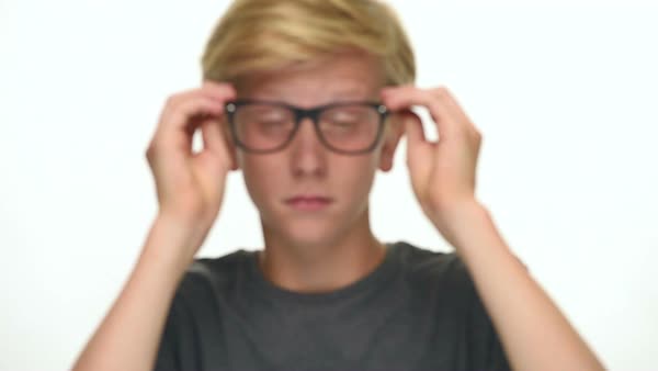 Blond Teenager Student Boy With Black Glasses Tries To Focus Looking At Camera Isolated On White Blond Teenager Student Boy With Black Glasses Tries To Focus Looking At Camera Isolated On White