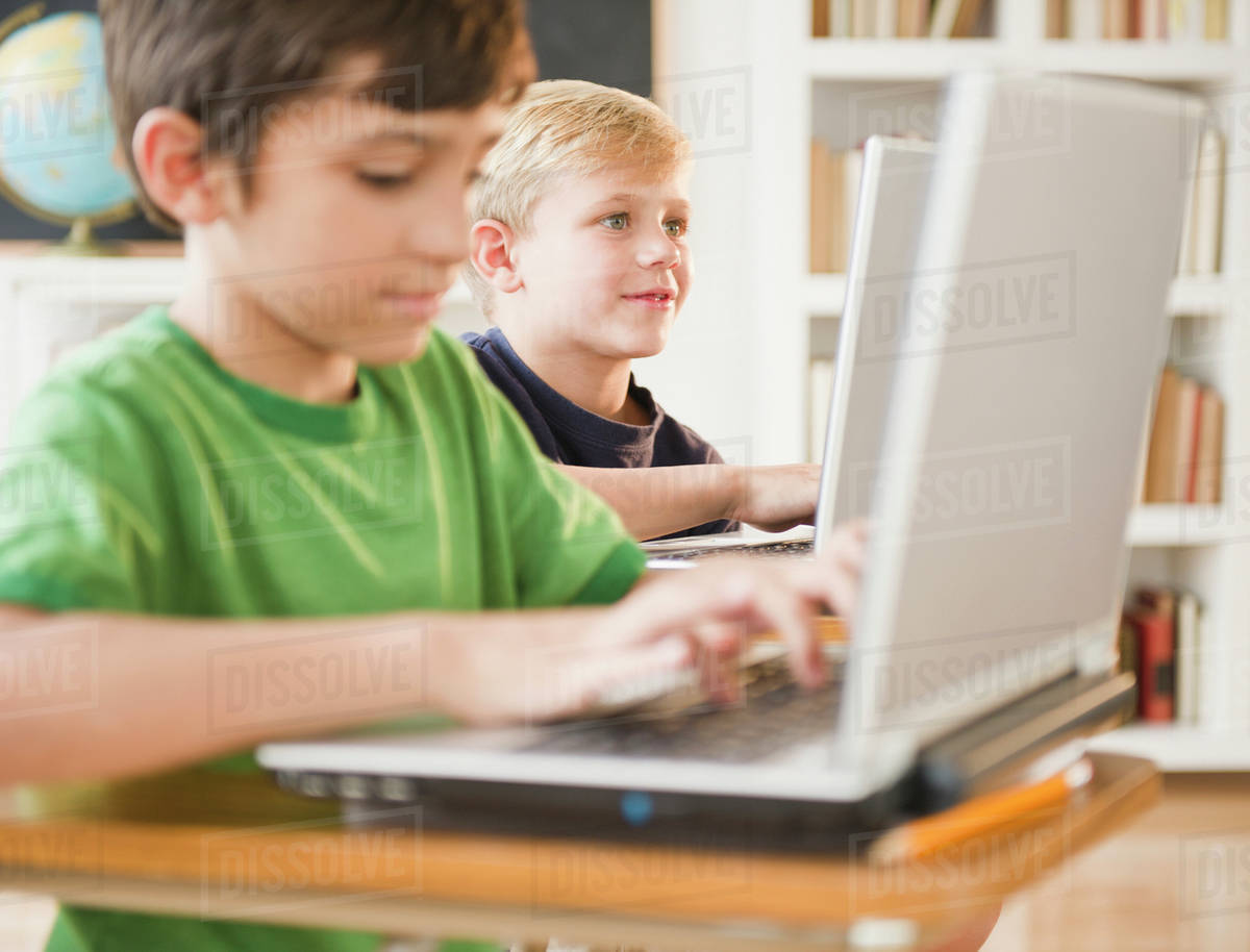Boys using laptops in classroom - Royalty-free Stock Photo | Dissolve
