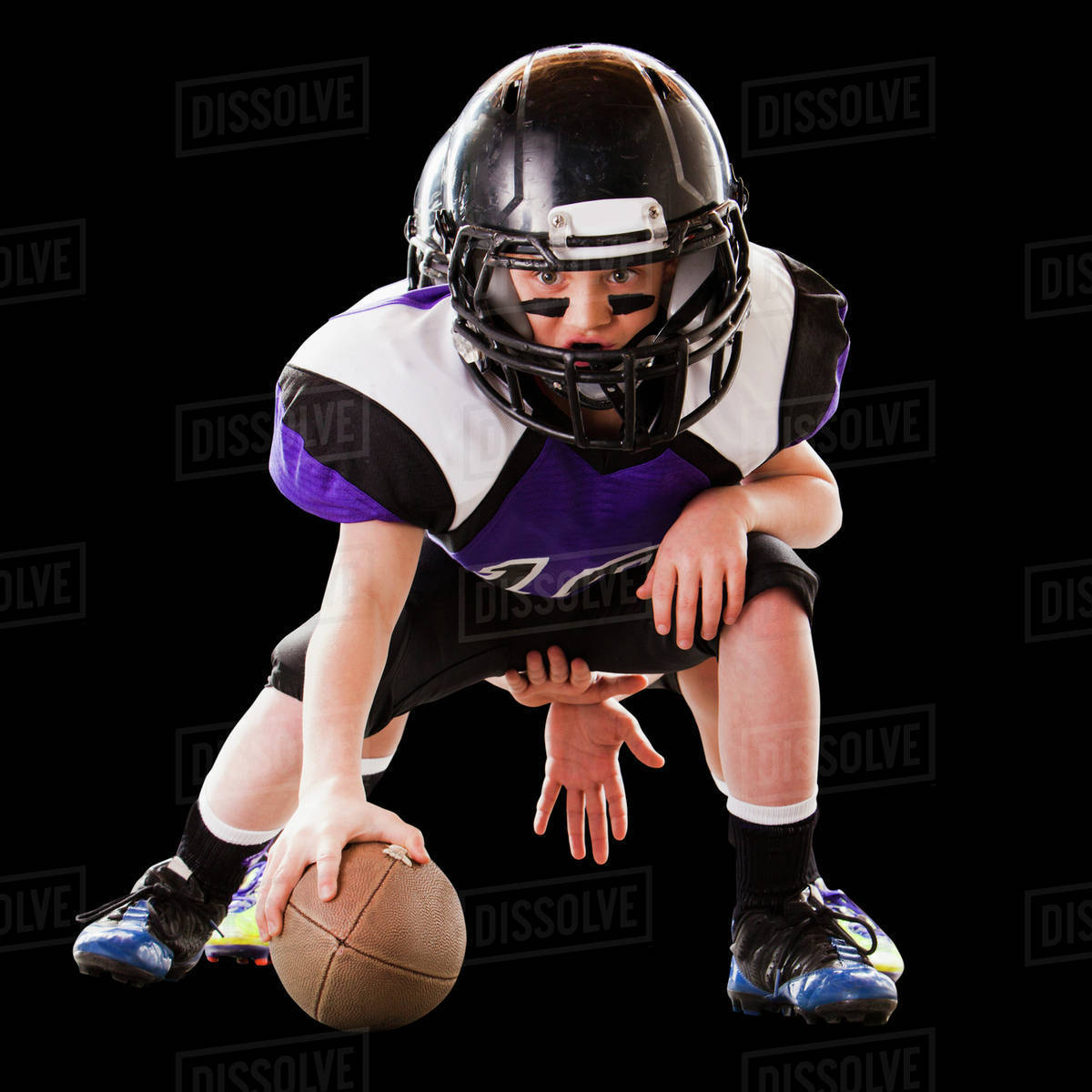 Football player hiking ball to quarterback Stock Photo Dissolve