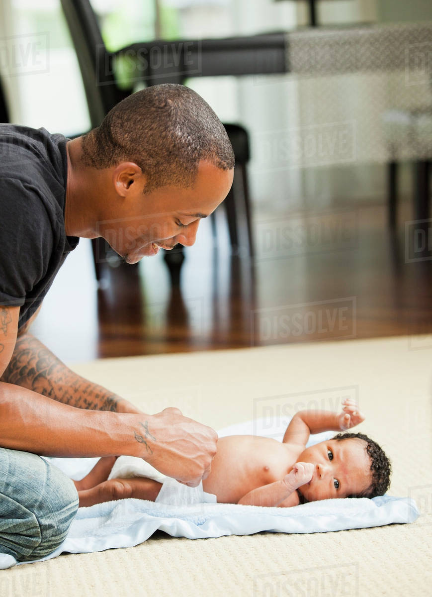 Father changing newborn baby's diaper Stock Photo Dissolve