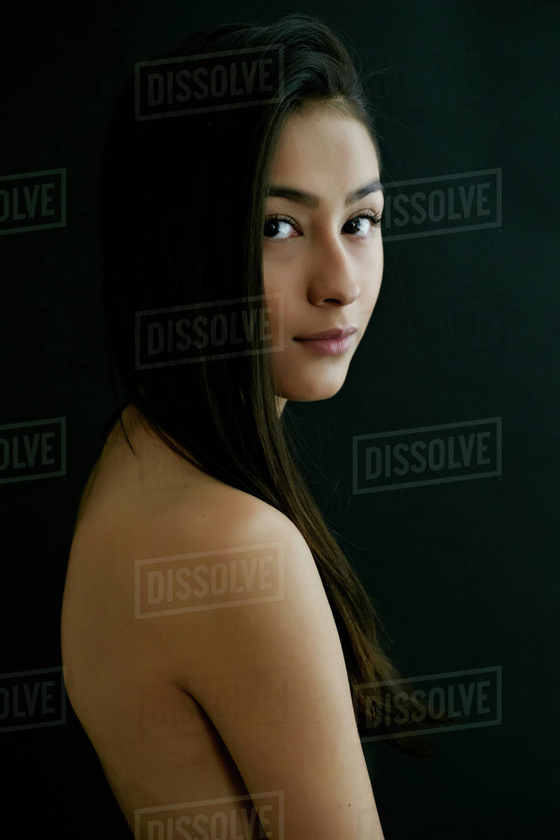 Nude Hispanic woman looking over shoulder - Stock Photo - Dissolve