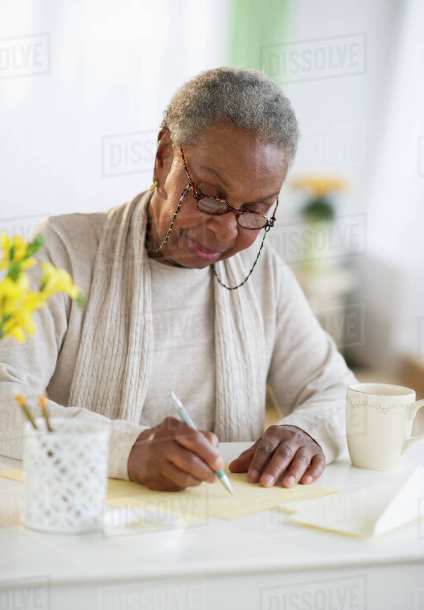 Black woman writing letter - Stock Photo - Dissolve