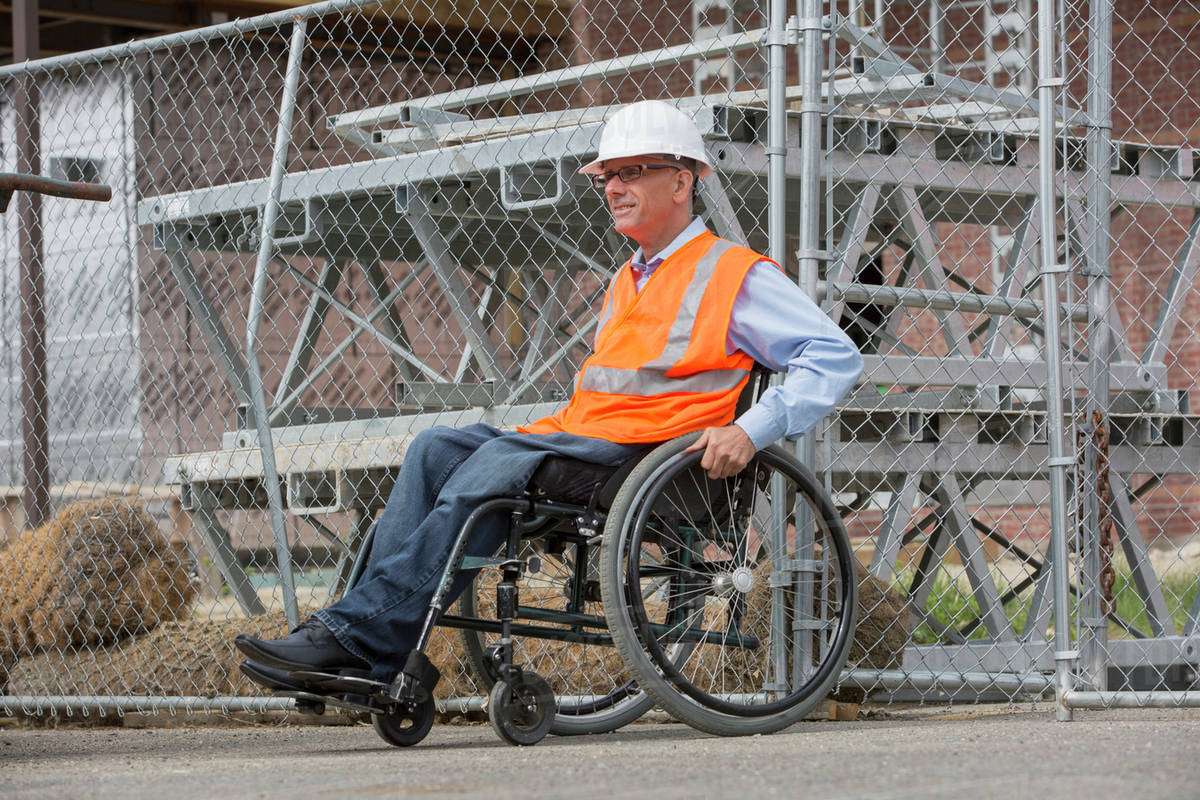 Caucasian engineer in wheelchair on construction site Stock Photo