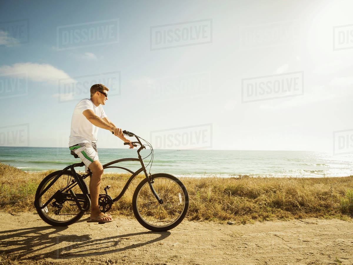 Caucasian Man Riding Bicycle On Beach Stock Photo Dissolve Caucasian Man Riding Bicycle On Beach