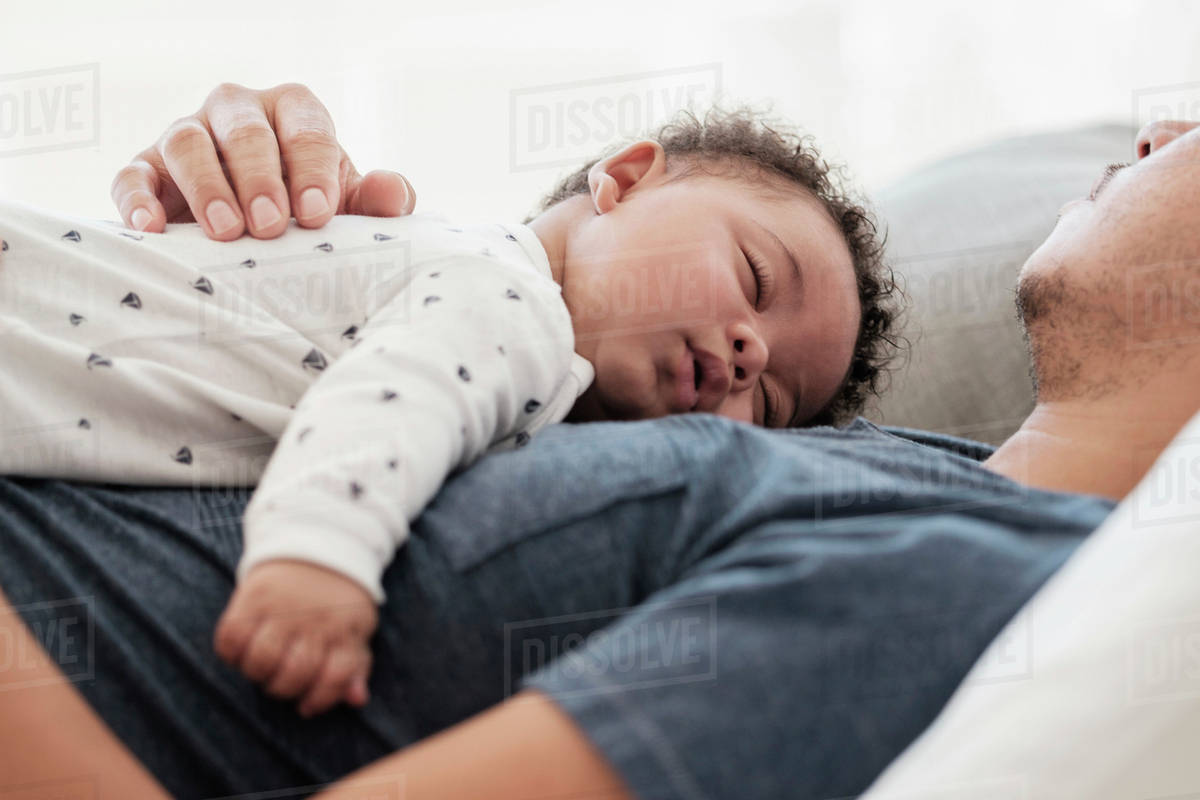 Father and baby son sleeping on bed Stock Photo Dissolve