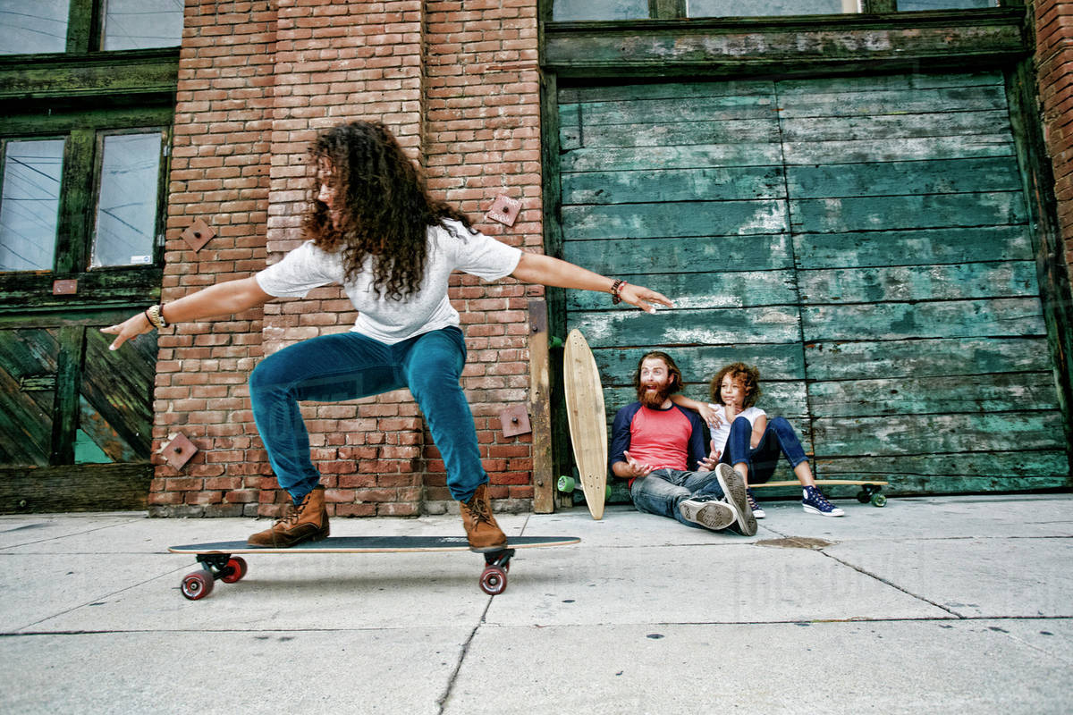 Family riding skateboards on sidewalk Stock Photo Dissolve