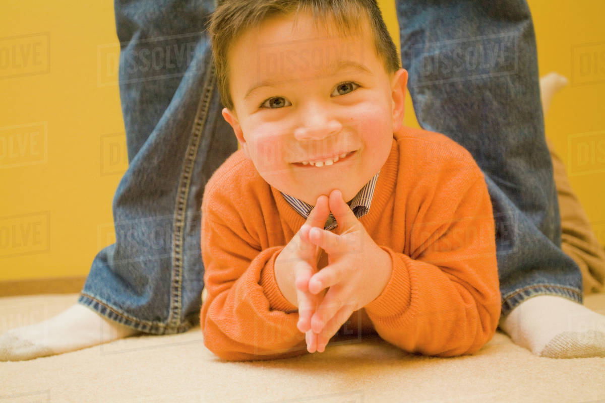 Mixed Race Boy Laying On Floor Stock Photo Dissolve