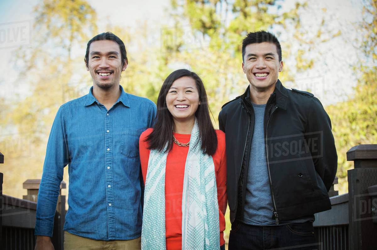 Adult Chinese siblings smiling outdoors Stock Photo Dissolve