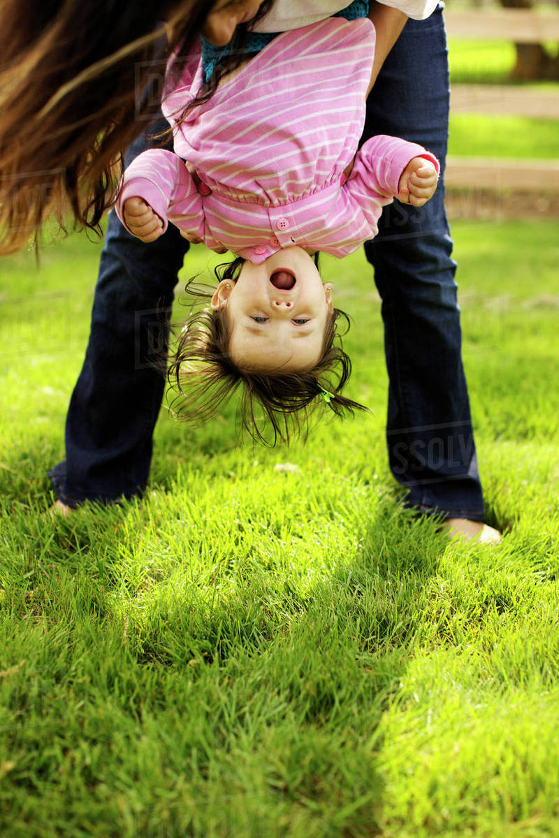 Mother holding toddler daughter upside down Stock Photo Dissolve
