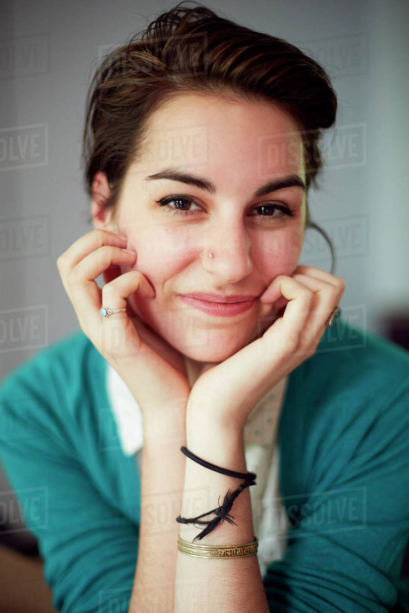 Close up of woman resting chin in hands Stock Photo Dissolve