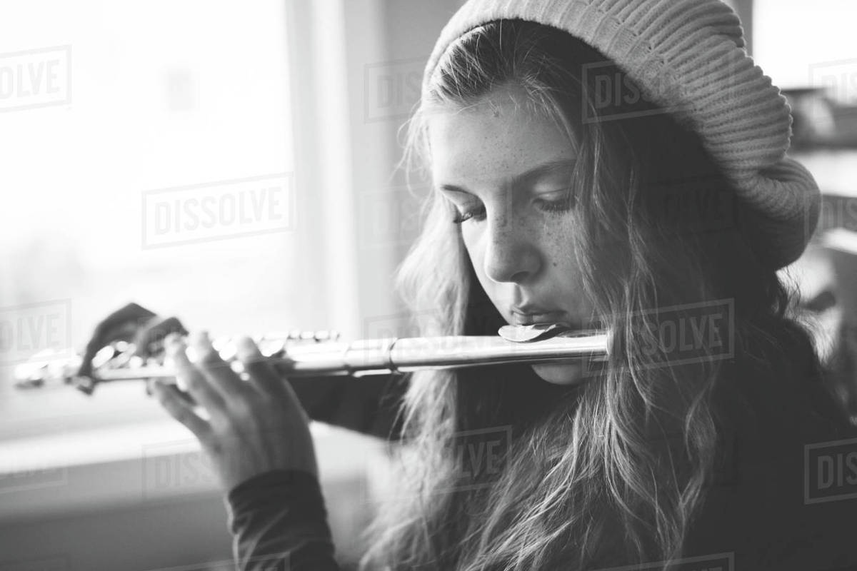 Close up of Caucasian girl playing flute Stock Photo Dissolve
