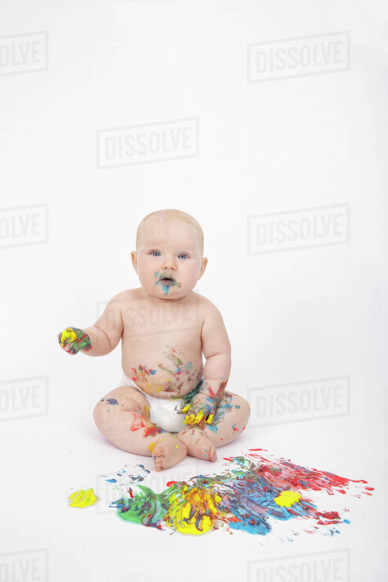 Caucasian baby playing with paint Stock Photo Dissolve