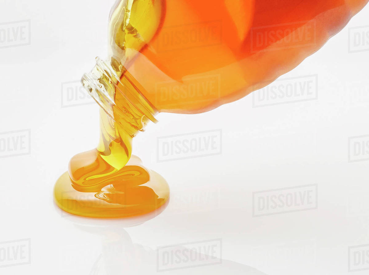 Honey pouring from bottle Stock Photo Dissolve