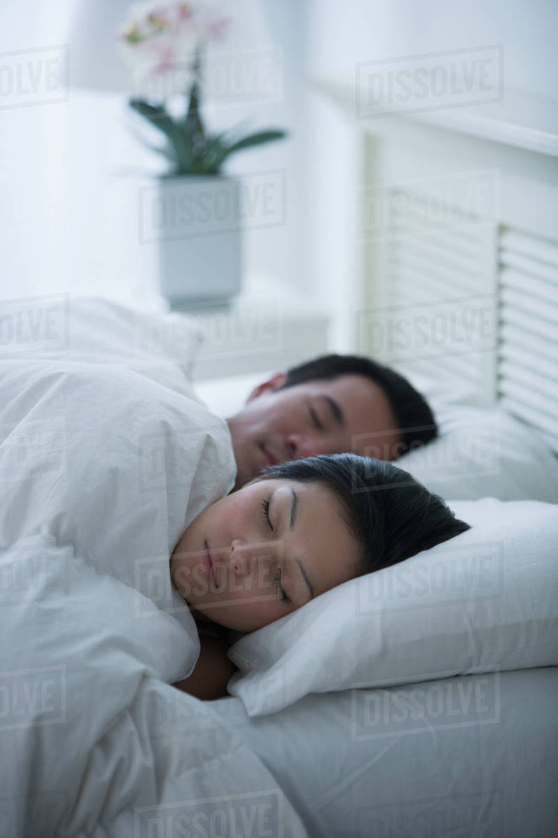 Asian couple sleeping in bed Stock Photo Dissolve