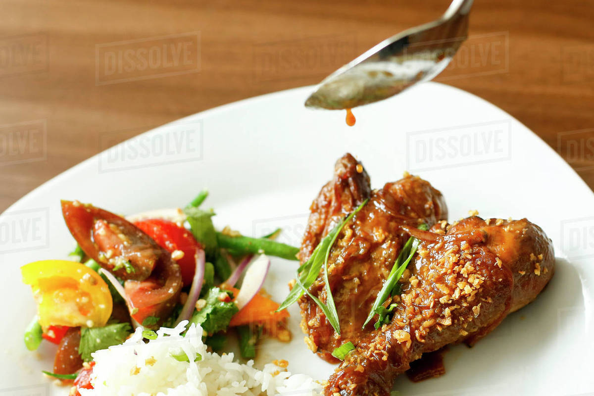 Spoon dripping sauce on meat Stock Photo Dissolve