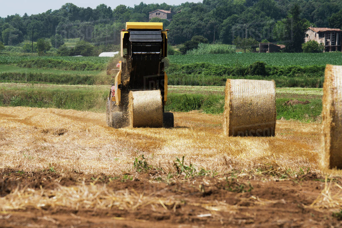 Tractor baling hay in field Stock Photo Dissolve