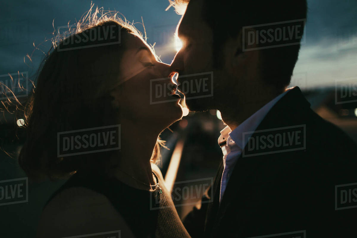 Caucasian couple kissing at night Stock Photo Dissolve