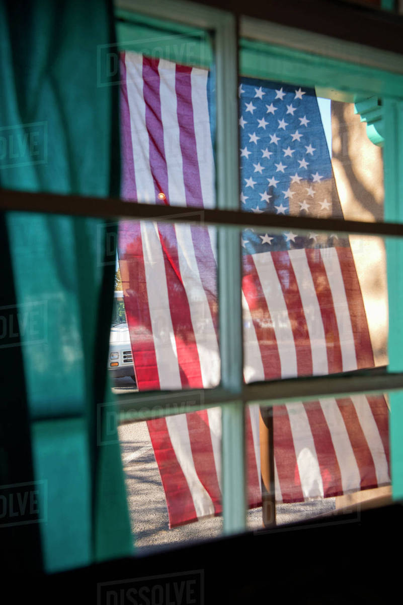 American flag hanging outside window Stock Photo Dissolve