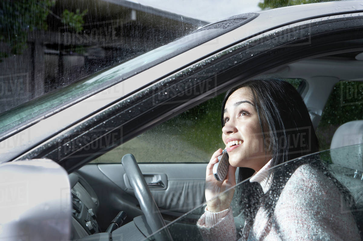 Indian woman watching rain from car - Royalty-free Stock Photo | Dissolve