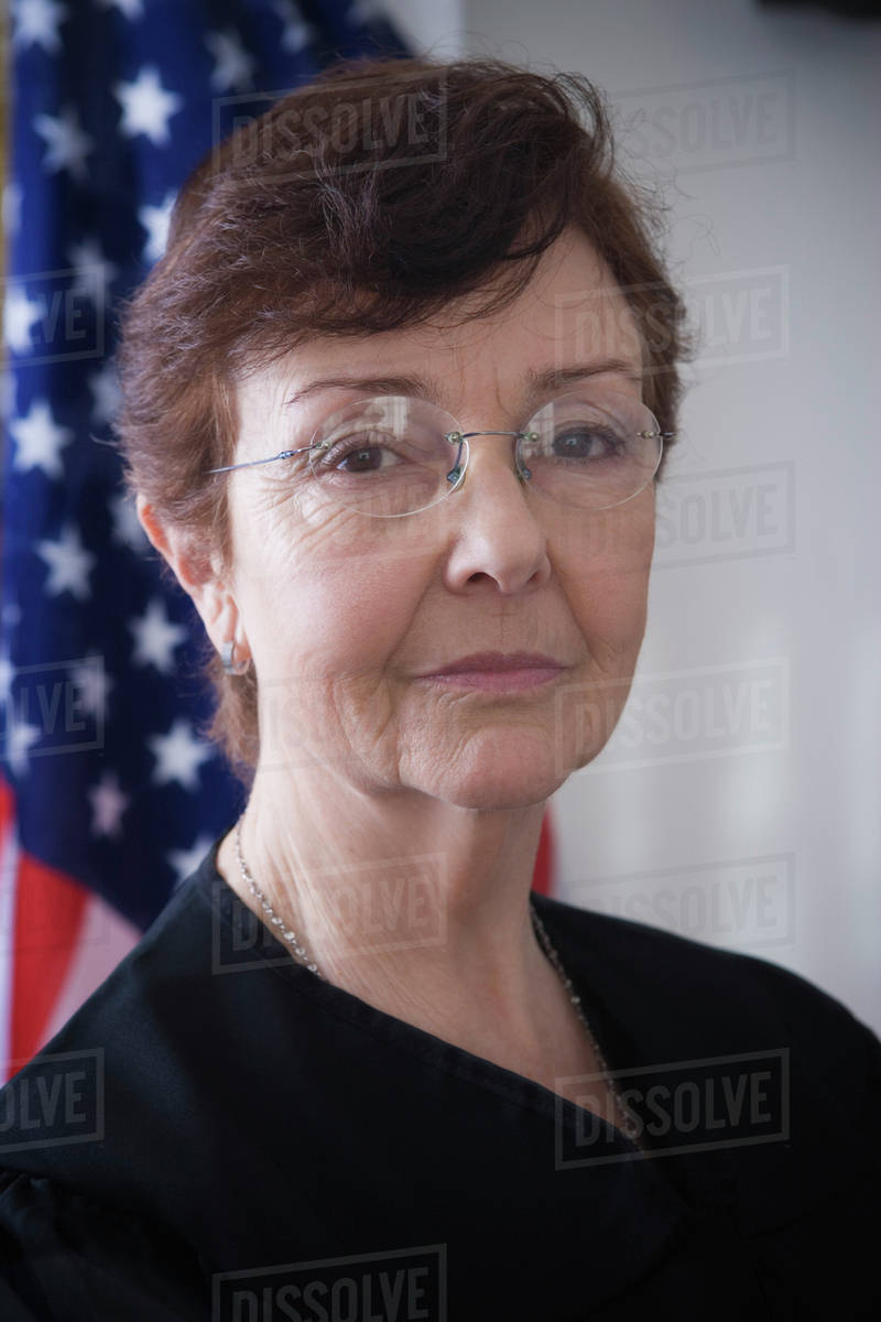 Hispanic judge posing by American flag Stock Photo Dissolve