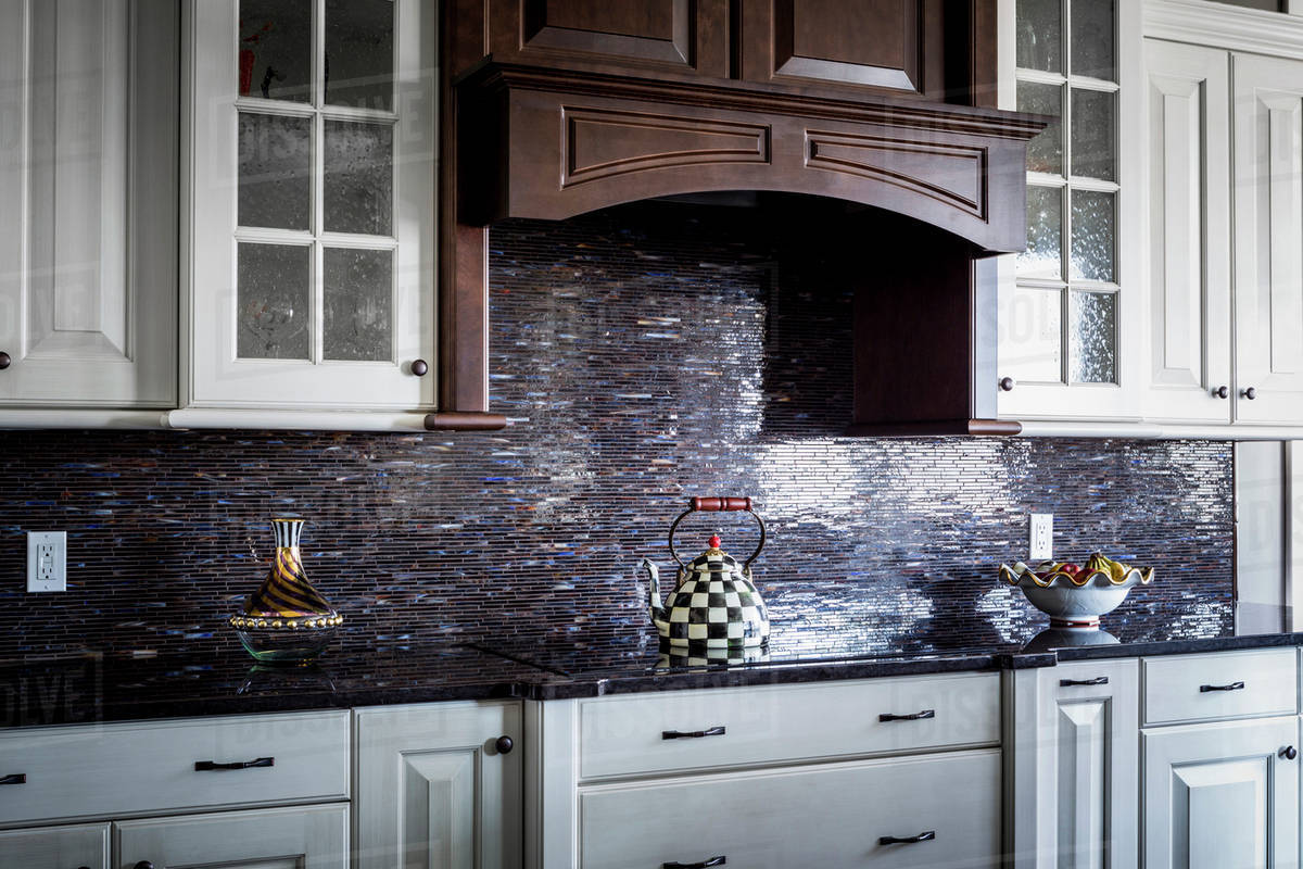 Checkered teapot on stove in kitchen Stock Photo Dissolve