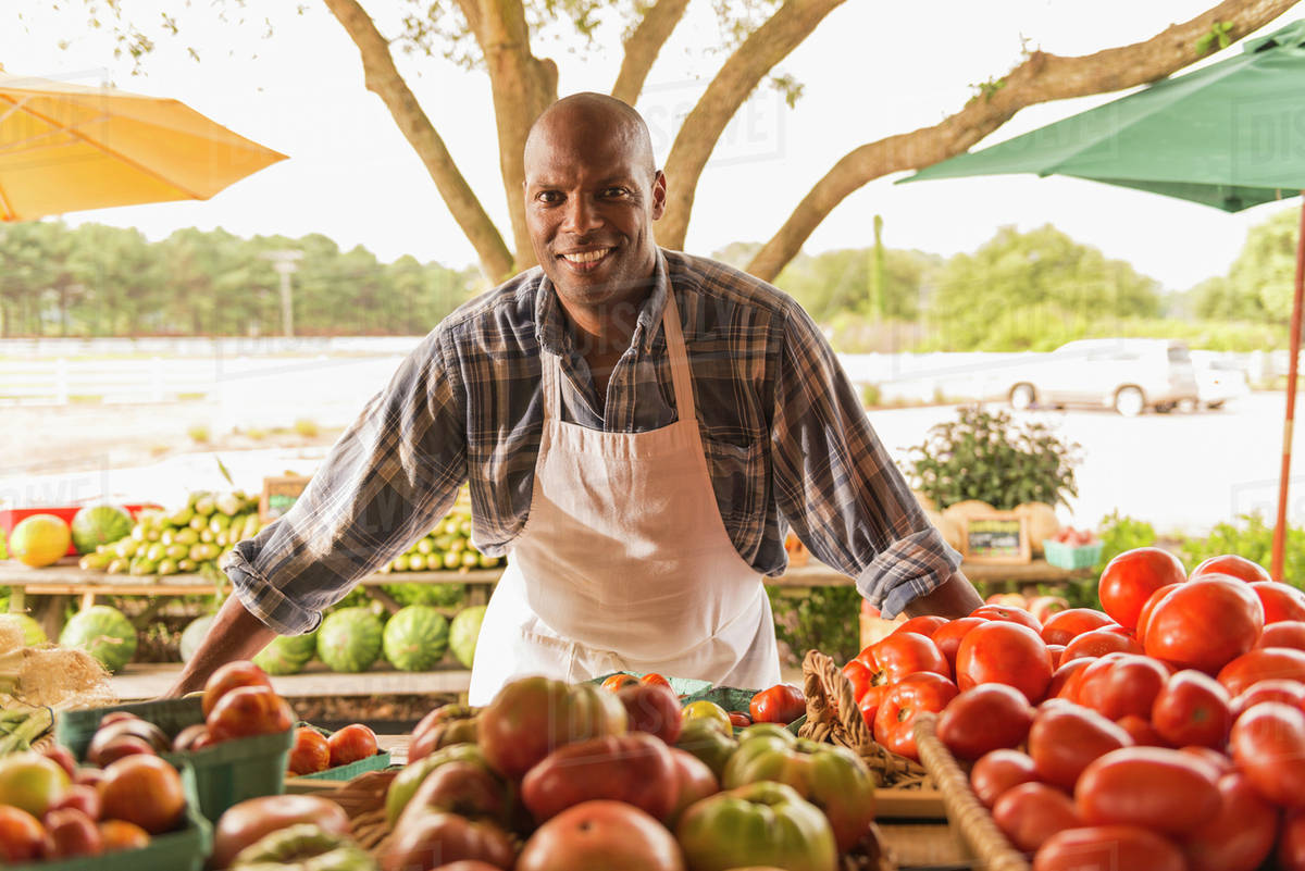 African American vendor smiling at farmers market Stock Photo Dissolve