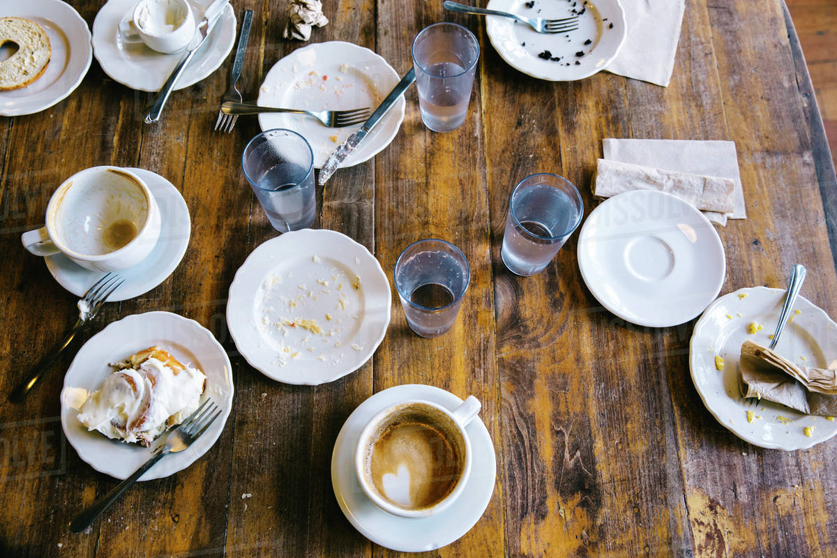 Empty plates, coffee cups and glasses on cafe table Royalty-free stock photo