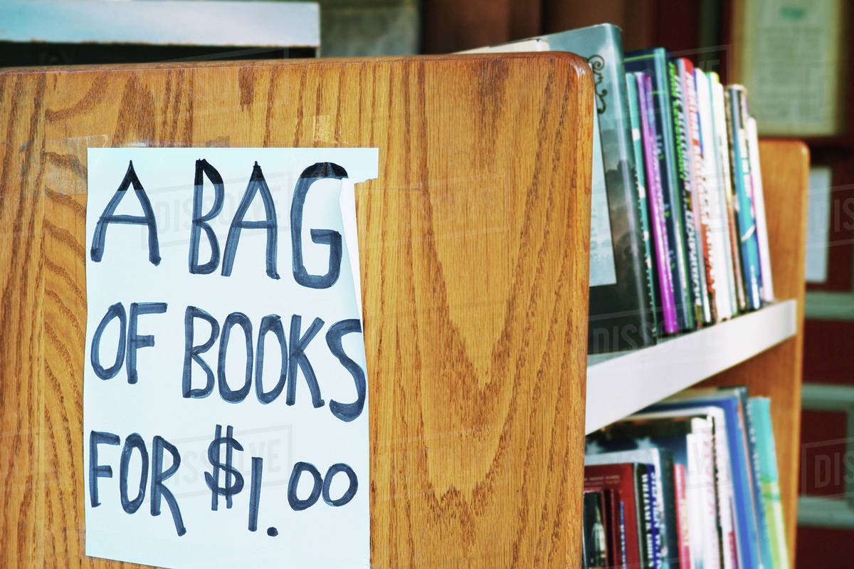 a bag of books for 1 00 sign in library stock photo dissolve