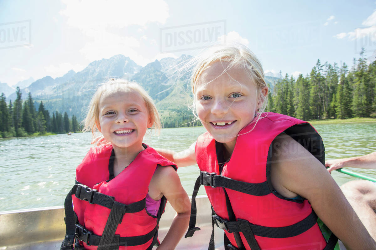 Caucasian girls wearing life jackets in canoe Stock Photo Dissolve