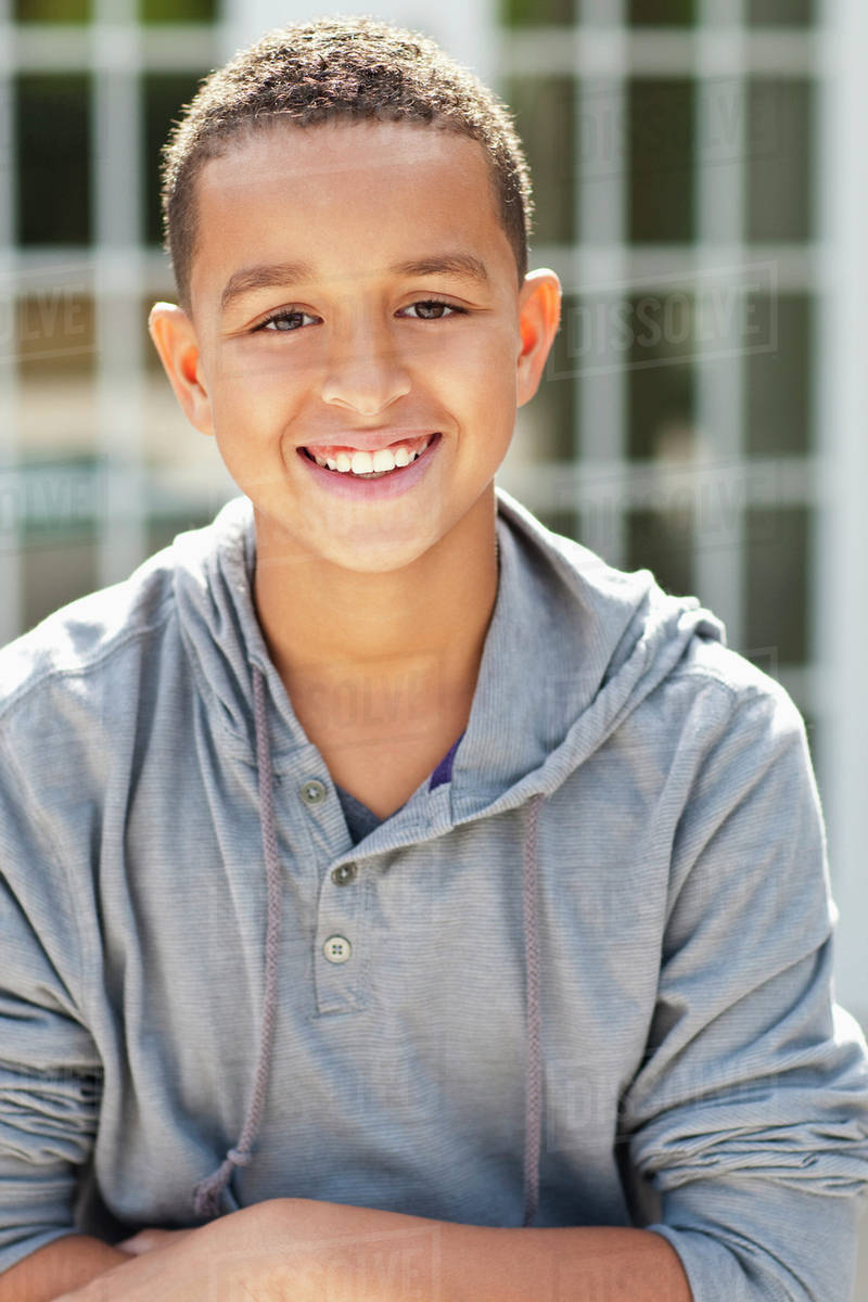 Close up of mixed race boy smiling outdoors Stock Photo Dissolve