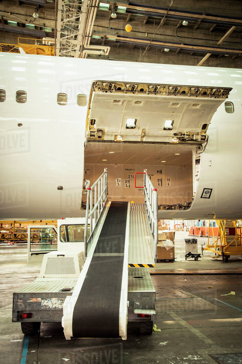 Conveyor belt leading to airplane cargo hold Stock Photo Dissolve