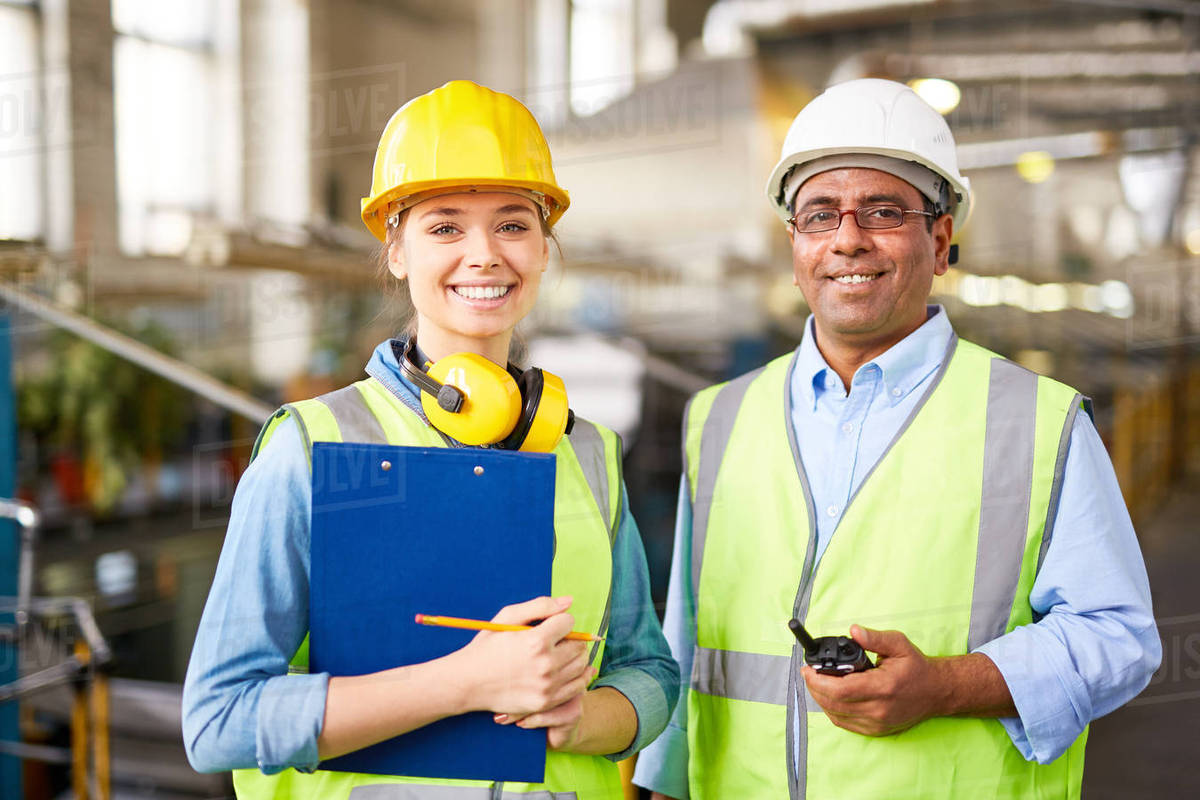 Mature and young engineers in uniform looking at camera Stock Photo