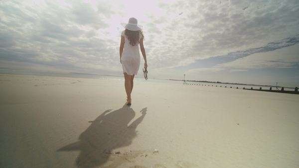 Young Woman Walking Along The Beach In Slow Motion With Her Shoes Young Woman Walking Along The Beach In Slow Motion With Her Shoes Hand Stock Video Footage Dissolve