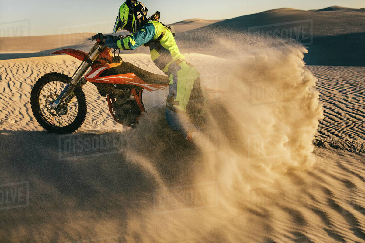 Motocross rider riding his bike on a sand dune. Motorcycle rider in