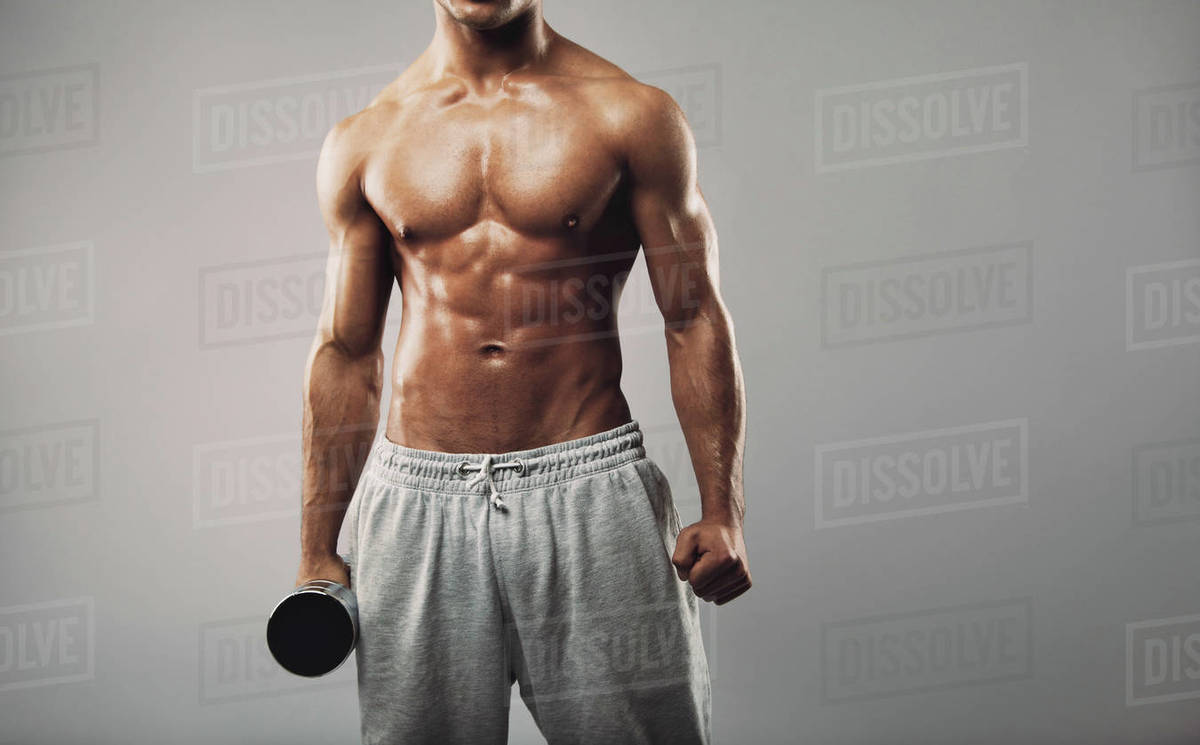 Cropped image of young muscular male fitness model wearing sweatpants