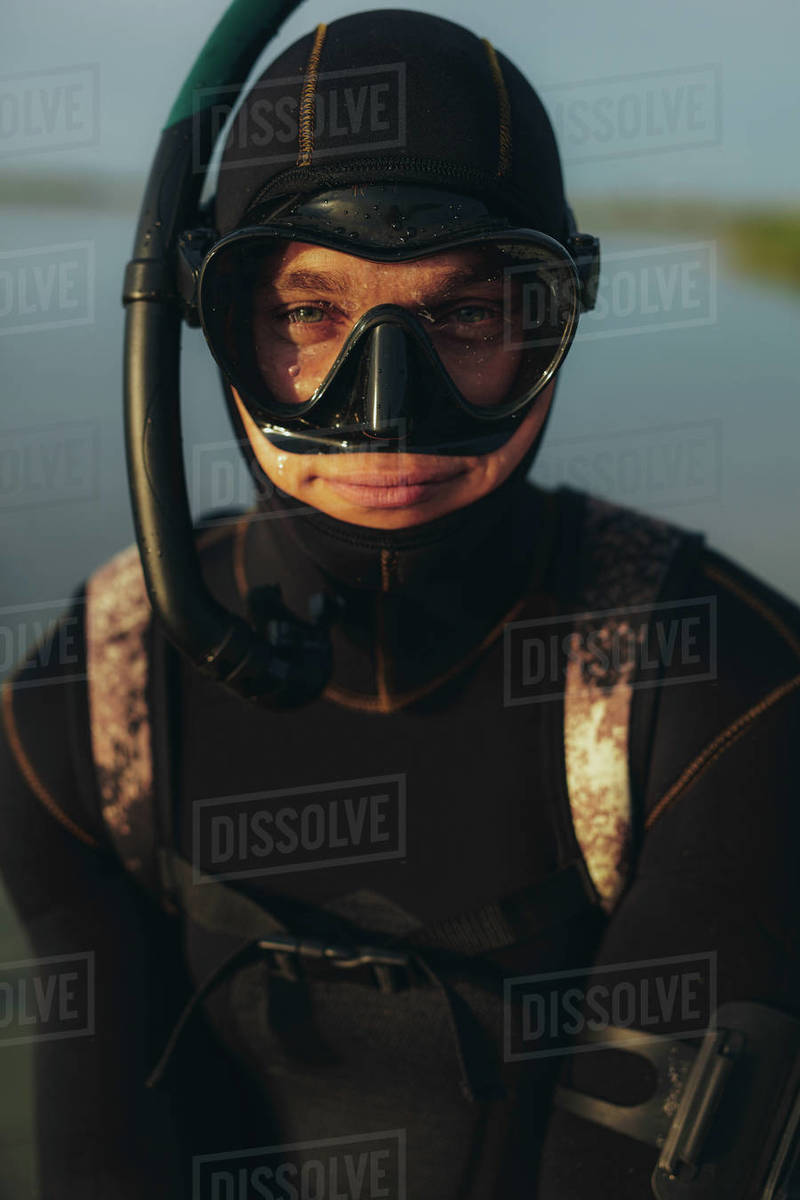 Closeup of young guy in scuba gear looking at camera. Male diver
