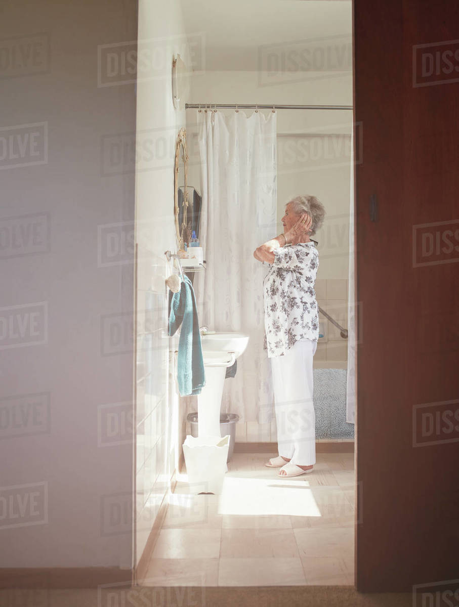 Full length indoor shot of elderly woman getting ready at dresser