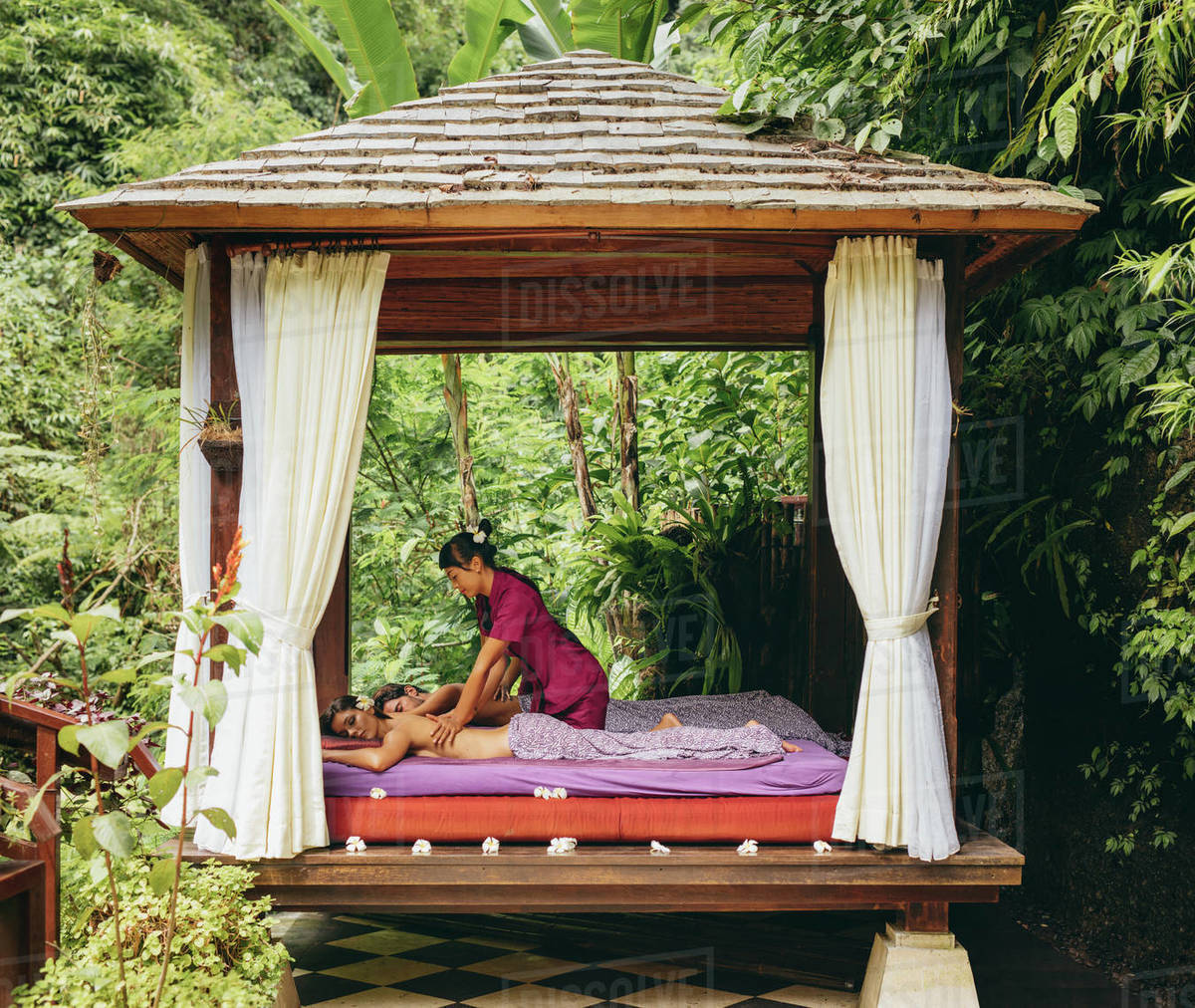 Shot of young man and woman receiving massage at health spa in luxury