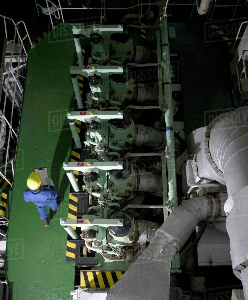 Aerial view of engineer with maintenance chart in ships engine room
