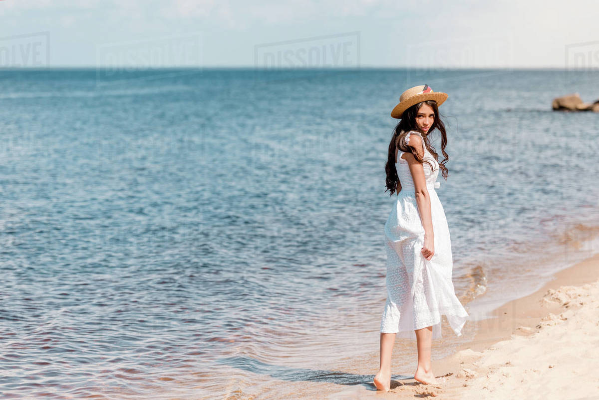 straw hat and white dress walking 