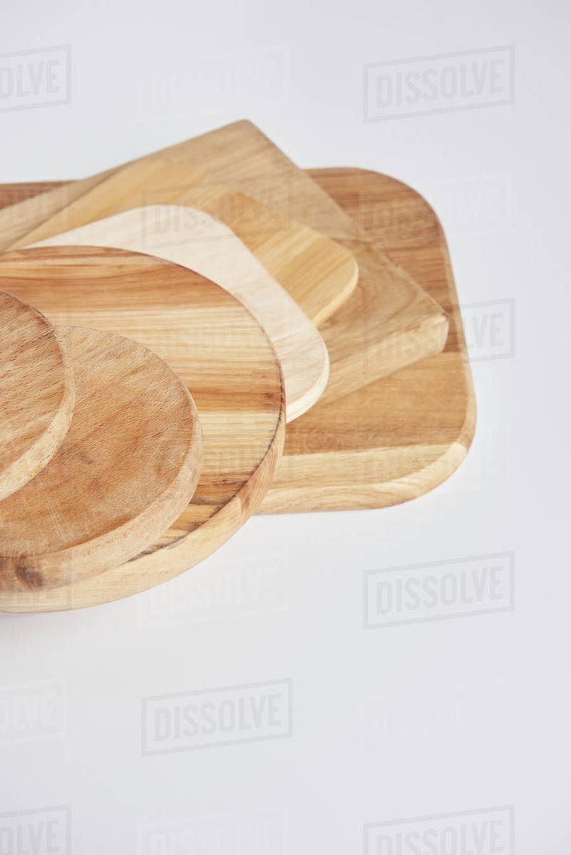 Close up shot of stack of different wooden cutting boards on white