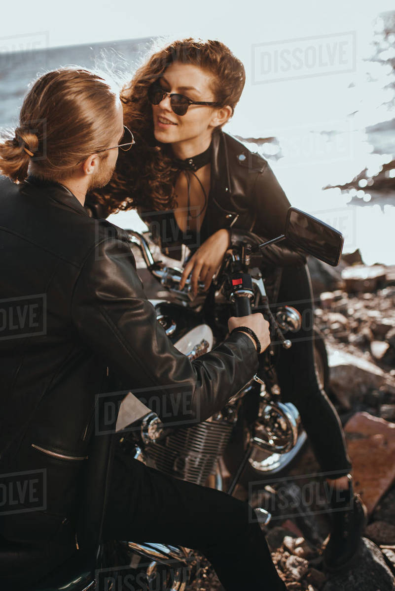 Happy girl flirting with her boyfriend while he sitting on