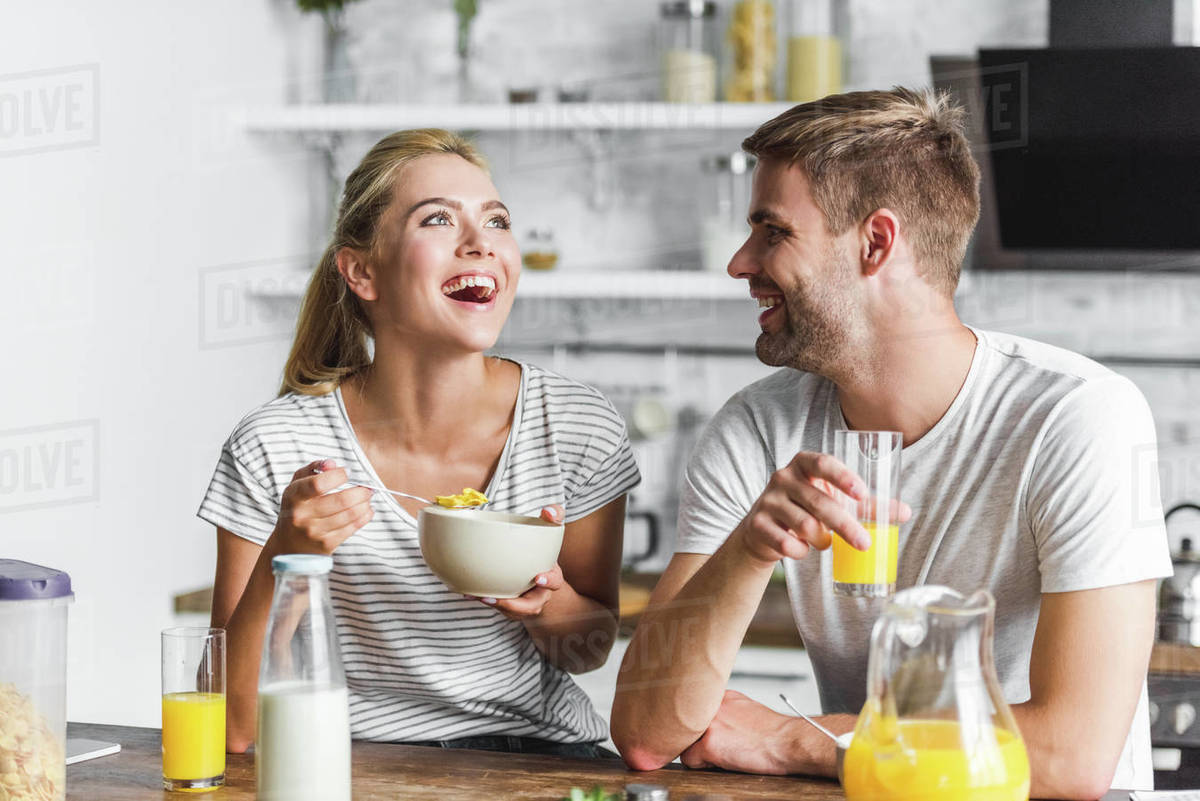couple having breakfast and laughing in kitchen Royalty-free