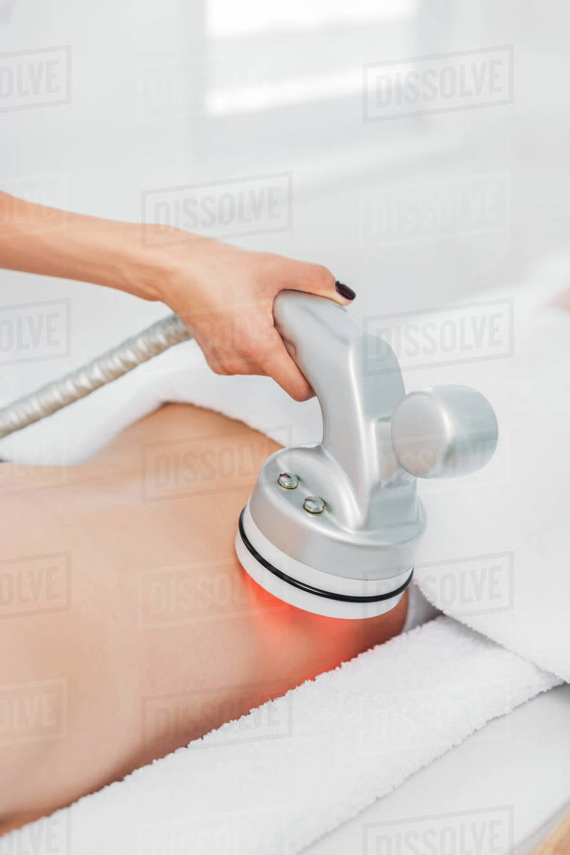 Cropped shot of woman on massage table getting electrical massage done
