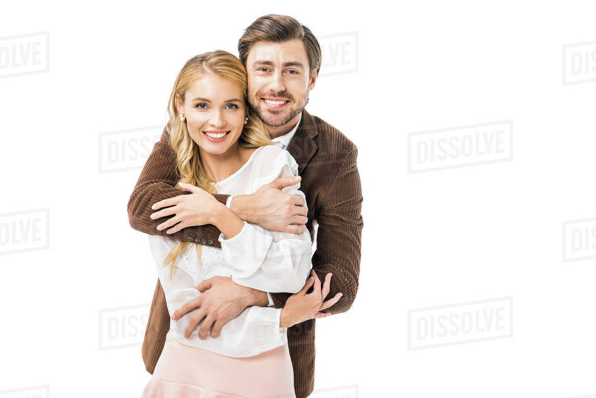 Happy stylish man in jacket hugging girlfriend isolated on white