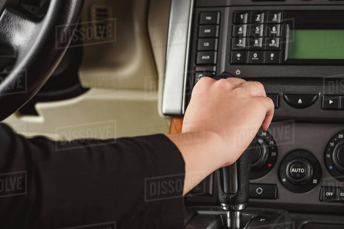 Cropped shot of woman changing gear while driving car Stock Photo Dissolve