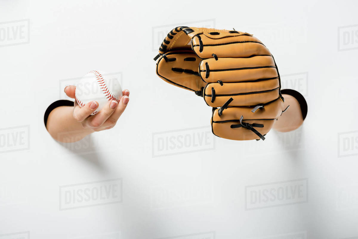 cropped image of woman holding baseball glove and ball through holes on