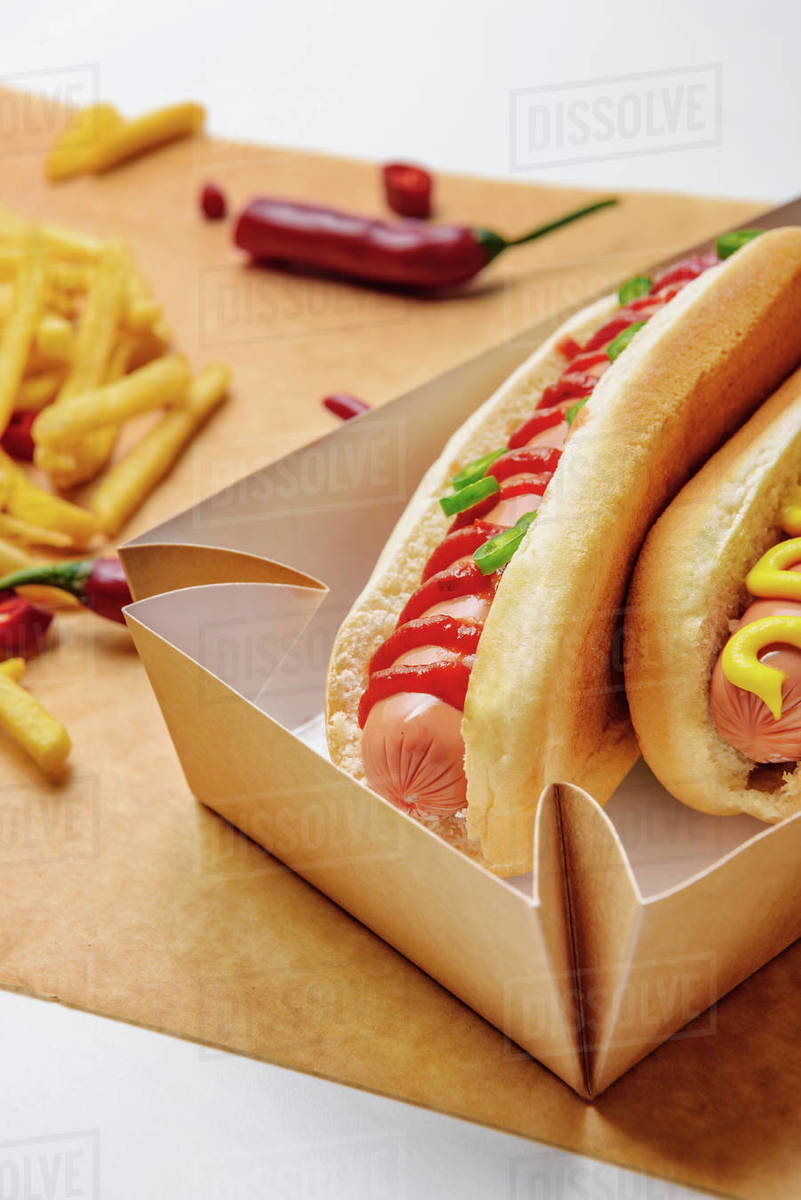 Close-up shot of hot dogs in cardboard tray with French fries on ...