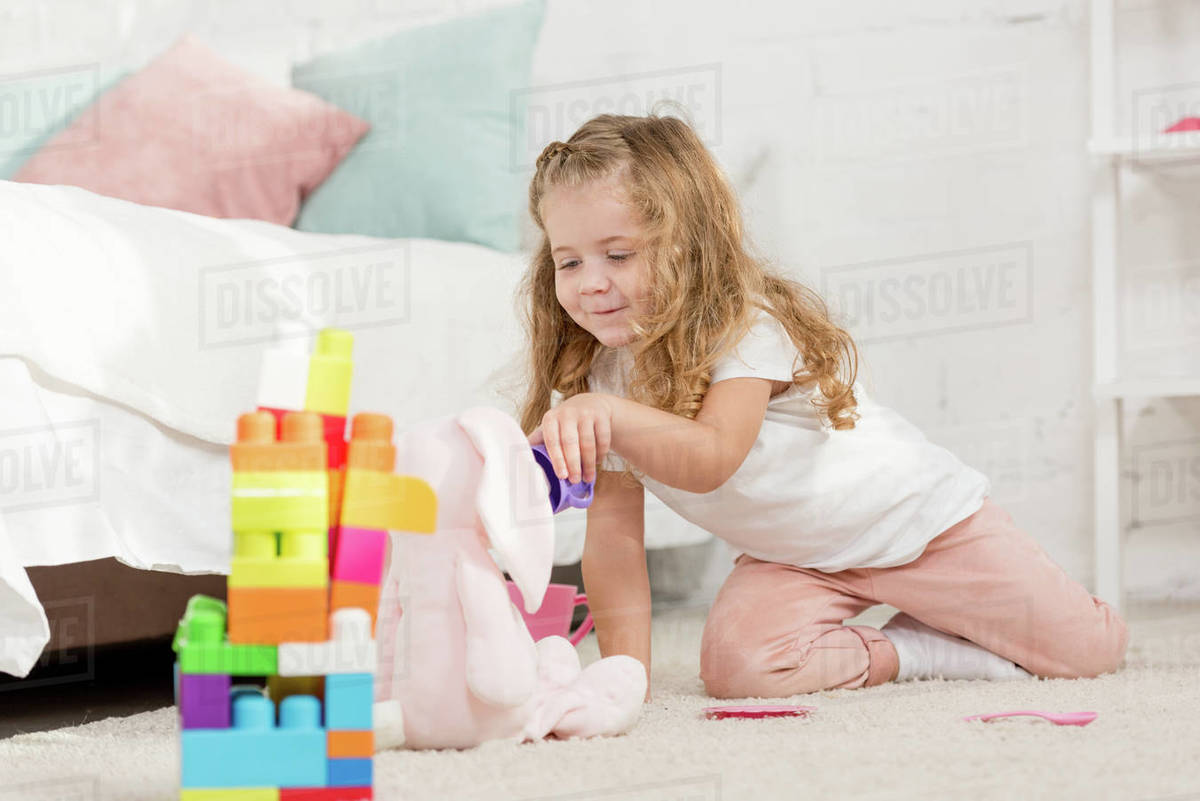 Adorable Kid With Curly Hair Playing With Soft Rabbit And Plastic