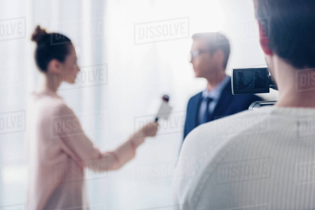 Selective focus of businessman in glasses giving video interview to ...